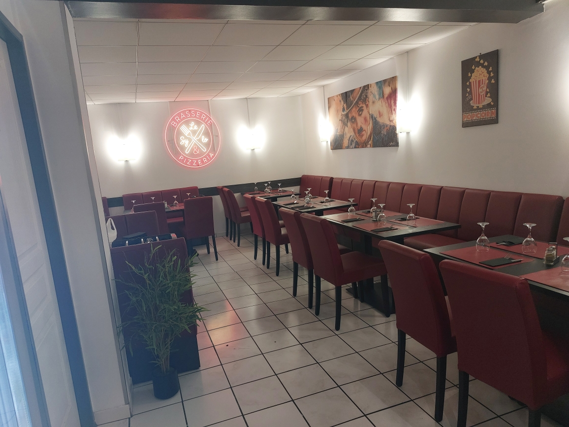 Salle du Sylo avec banquettes rouges et enseigne néon
